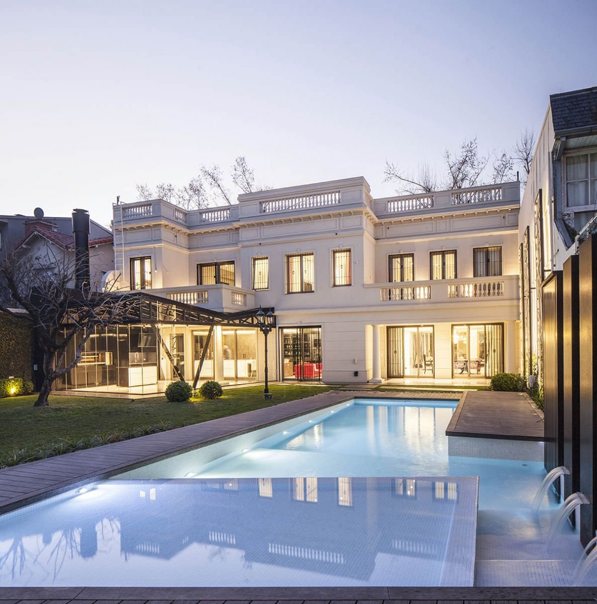 En la casa urbana todo el jard&iacute;n posterior es una gratificaci&oacute;n a cielo abierto. La larga piscina con zona playa, deck y fuentes de agua, termina en un gran solarium. La superficie de la casa se extiende en una estructura vidriada donde se ubica el espectacular quincho (Casa Pemor&aacute;n, Vanguarda Arquitectos)
